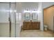 This bathroom offers a glass shower, separate tub, double sinks, wood cabinets and tile floor at 18249 W Mauna Loa Ln, Surprise, AZ 85388