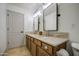 Bathroom featuring dual sinks with marble countertops, and a door at 18249 W Mauna Loa Ln, Surprise, AZ 85388
