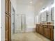 Bright bathroom features a glass shower, separate tub, double sinks, and wood cabinets at 18249 W Mauna Loa Ln, Surprise, AZ 85388
