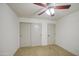 Cozy bedroom featuring a ceiling fan and convenient closet and door placement at 18249 W Mauna Loa Ln, Surprise, AZ 85388