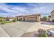 Sprawling ranch-style home featuring a wide driveway with desert landscaping, complemented by a tile roof and an attached two-car garage at 18249 W Mauna Loa Ln, Surprise, AZ 85388