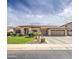 A sprawling ranch-style home boasts a three-car garage, desert landscaping, and a tile roof, adding to its curb appeal at 18249 W Mauna Loa Ln, Surprise, AZ 85388