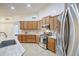 A modern kitchen featuring light countertops, stainless steel appliances, and warm wood cabinets for a contemporary feel at 18249 W Mauna Loa Ln, Surprise, AZ 85388