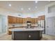 Expansive kitchen featuring stainless steel appliances, light countertops, a stylish island, and abundant wooden cabinetry at 18249 W Mauna Loa Ln, Surprise, AZ 85388