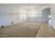 Large living room with neutral carpet, bright white walls, a chandelier, and plenty of natural light at 18249 W Mauna Loa Ln, Surprise, AZ 85388