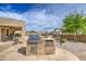 Outdoor kitchen features a built-in grill, stainless steel refrigerator, and ample counter space for outdoor entertainment at 18249 W Mauna Loa Ln, Surprise, AZ 85388