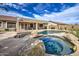 Stunning backyard pool and spa surrounded by natural rocks and beautiful stonework at 18249 W Mauna Loa Ln, Surprise, AZ 85388