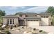 Beautiful single-story home with a stone-accented facade, desert landscaping, and a two-car garage at 19988 W Marshall Ave, Litchfield Park, AZ 85340