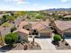 Stunning aerial view of the home with red tile roof, solar panels, well maintained desert landscaping, and a three-car garage at 20655 N 273Rd Ave, Buckeye, AZ 85396