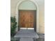 Elegant wood double front door with detailed carvings, set within a brick entryway and green landscaping at 225 N Standage -- # 139, Mesa, AZ 85201