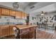 Kitchen featuring dark wood floors, wood cabinets, granite counters, island and view to dining room at 225 N Standage -- # 139, Mesa, AZ 85201
