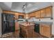 Kitchen featuring dark wood floors, wood cabinets, granite counters, and a dark island at 225 N Standage -- # 139, Mesa, AZ 85201