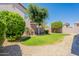 A private backyard has a grassy area and is surrounded by mature landscaping and a brick wall at 25860 N 47Th Pl, Phoenix, AZ 85050