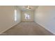 Bright bedroom with a ceiling fan, neutral carpet, and a window letting in natural light at 25860 N 47Th Pl, Phoenix, AZ 85050