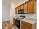 Kitchen featuring granite countertops, wooden cabinets, and black appliances with wood look tile flooring at 25860 N 47Th Pl, Phoenix, AZ 85050