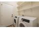A bright laundry room includes a newer Samsung washer and dryer, floating shelves, and access to the garage at 25860 N 47Th Pl, Phoenix, AZ 85050
