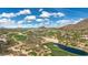 Aerial view of a desert community, showing golf course, mountains, and sprawling residences at 26049 N 104Th Pl, Scottsdale, AZ 85255