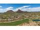 Aerial view of the community showcasing a golf course, residences and mountain backdrop at 26049 N 104Th Pl, Scottsdale, AZ 85255