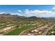 Desert community with golf course, lake, mountains, and homes; an aerial perspective at 26049 N 104Th Pl, Scottsdale, AZ 85255