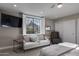A contemporary bedroom with large window with mountain views and a sitting area at 26049 N 104Th Pl, Scottsdale, AZ 85255
