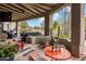 Inviting covered patio with comfortable seating and desert landscaping, perfect for outdoor relaxation and entertaining at 26049 N 104Th Pl, Scottsdale, AZ 85255