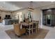 Open-concept dining area with a rustic wooden table, unique light fixture, and seamless flow to the living space at 26049 N 104Th Pl, Scottsdale, AZ 85255