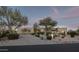 Stunning desert home featuring mature landscaping, gravel driveway, and ample curb appeal at twilight at 26049 N 104Th Pl, Scottsdale, AZ 85255