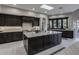 Modern kitchen with dark cabinetry, a large center island, and stainless steel appliances for a chef-inspired space at 26049 N 104Th Pl, Scottsdale, AZ 85255