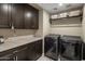 Functional laundry room with marble countertop, cabinets, and modern washer and dryer at 26049 N 104Th Pl, Scottsdale, AZ 85255