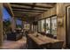 Inviting outdoor patio with wooden ceiling, dining area, and cozy lounge space featuring sliding glass doors at 26049 N 104Th Pl, Scottsdale, AZ 85255