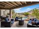 Covered patio overlooking the pool and backyard featuring comfortable seating and an outdoor dining set at 26049 N 104Th Pl, Scottsdale, AZ 85255