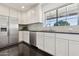 Bright kitchen features stainless steel appliances, white cabinets, and a large window at 2740 N 21St Dr, Phoenix, AZ 85009