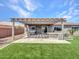 The backyard has a spa, patio, built-in grill, and covered pergola with a lush lawn at 30909 N 27Th Ave, Phoenix, AZ 85085