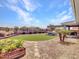 A well-maintained backyard boasts an outdoor kitchen, pergola, lush turf, and desert landscaping at 30909 N 27Th Ave, Phoenix, AZ 85085