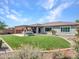 Relax in the backyard with green turf, covered patio, built-in grill, and desert landscaping at 30909 N 27Th Ave, Phoenix, AZ 85085