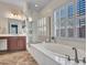This bathroom boasts a soaking tub and ample vanity space with wood cabinets at 30909 N 27Th Ave, Phoenix, AZ 85085