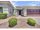 Inviting front facade featuring low maintenance landscaping, stone walkway, and attached garage at 30909 N 27Th Ave, Phoenix, AZ 85085
