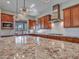 Wide kitchen view with granite countertops, kitchen island, wooden cabinets, and stainless steel appliances at 30909 N 27Th Ave, Phoenix, AZ 85085