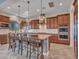 Full kitchen view with wooden cabinets, a kitchen island with seating, and stainless steel appliances at 30909 N 27Th Ave, Phoenix, AZ 85085