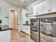 Well-equipped laundry room with front-load washer and dryer, sleek countertop, and ample storage cabinets at 30909 N 27Th Ave, Phoenix, AZ 85085