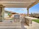 Outdoor grill area under a pergola with desert landscaping at 30909 N 27Th Ave, Phoenix, AZ 85085