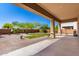 An outdoor covered patio overlooks a spacious backyard with grass, desert landscaping and brick pavers at 31604 N 19Th Ave, Phoenix, AZ 85085