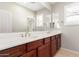 Bathroom with double sink vanity, plantation shutters, and large mirror at 31604 N 19Th Ave, Phoenix, AZ 85085
