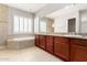 A bathroom boasts dual sinks, granite countertops, a tub, and tile flooring at 31604 N 19Th Ave, Phoenix, AZ 85085