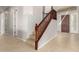 Inviting entryway featuring a carpeted staircase with dark wood banister and tile flooring at 31604 N 19Th Ave, Phoenix, AZ 85085
