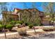 Two-story home featuring a three-car garage, stone accents, and a beautiful desert landscaped front yard at 31604 N 19Th Ave, Phoenix, AZ 85085
