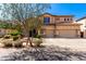 Two-story home featuring a three-car garage, stone accents, and a beautiful desert landscaped front yard at 31604 N 19Th Ave, Phoenix, AZ 85085