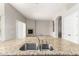 Close up of kitchen island sink with open floorplan and living room fireplace at 31604 N 19Th Ave, Phoenix, AZ 85085