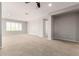 An open living room showcases neutral tones, plush carpeting, and a ceiling fan at 31604 N 19Th Ave, Phoenix, AZ 85085