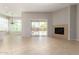 Open living room area with fireplace, tile flooring, and sliding glass door to the backyard at 31604 N 19Th Ave, Phoenix, AZ 85085